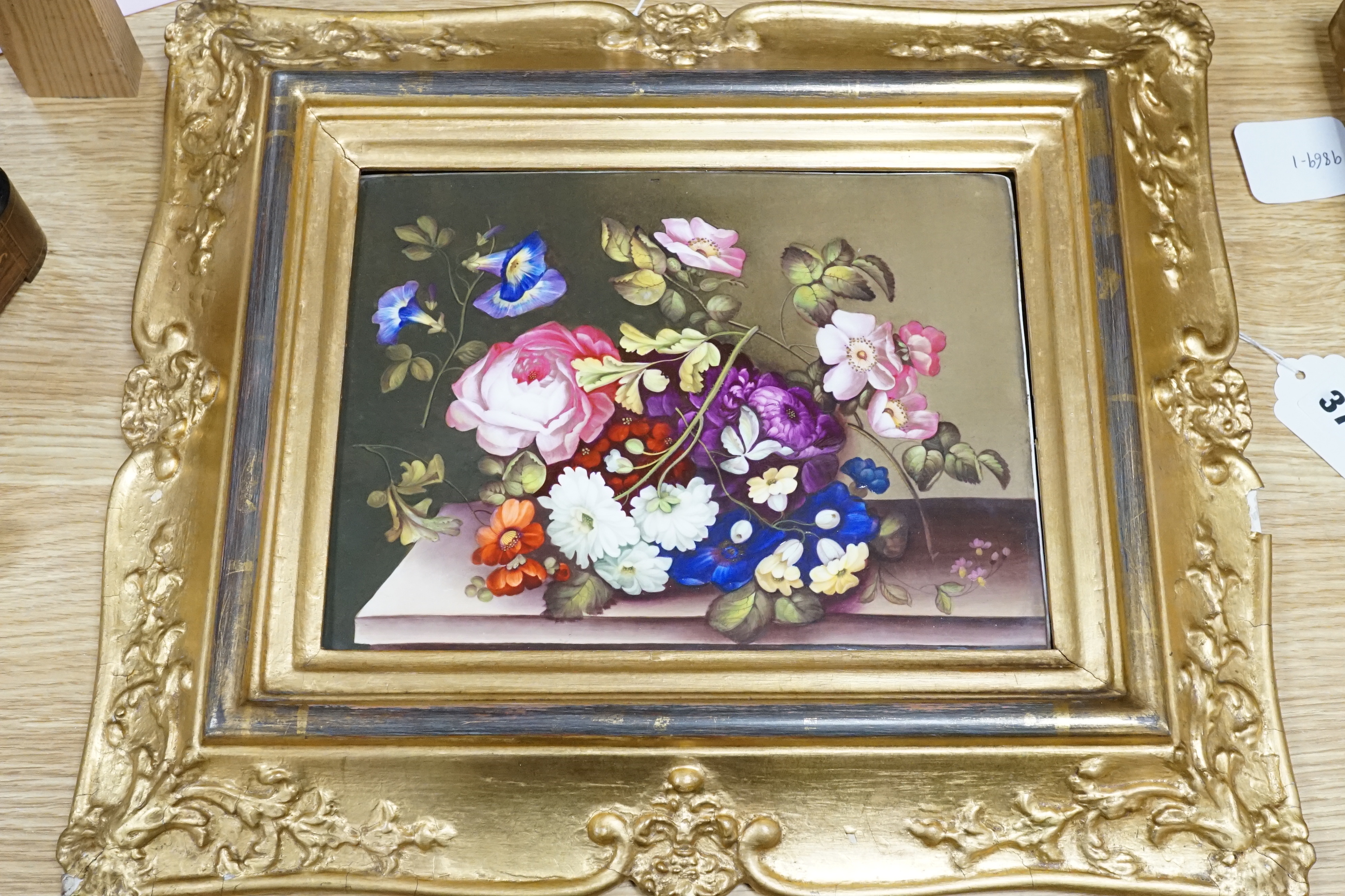 A 19th century English porcelain plaque of flowers on a ledge, in gilt frame, overall 41 x 35cm